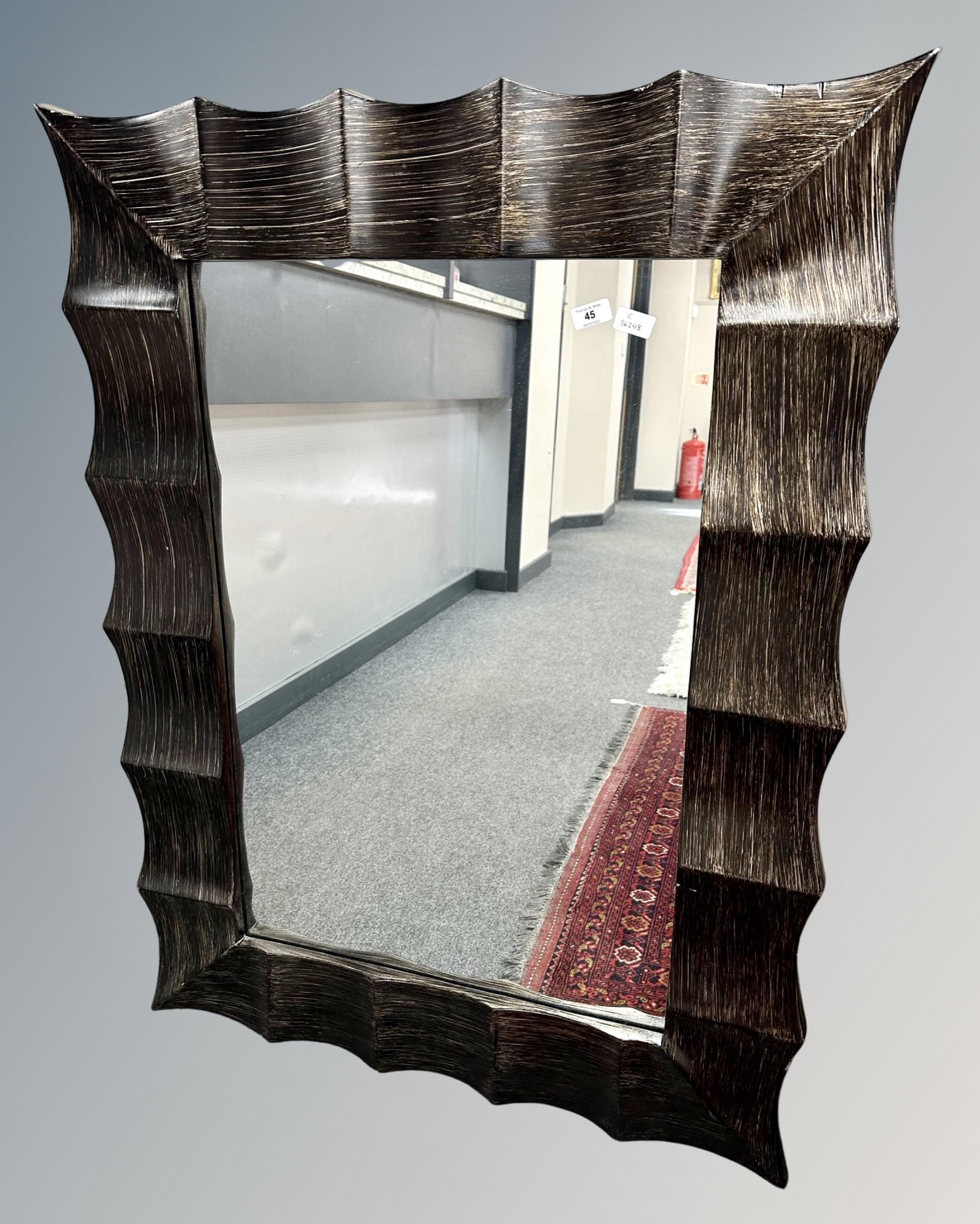 A contemporary mirror in wave frame, 92cm by 122cm.