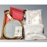 Two boxes containing assorted table linen, oval gilt framed bevel edged dressing mirror,