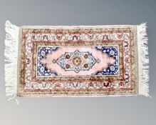 A Turkish rug with silk pile, 122cm by 63cm.