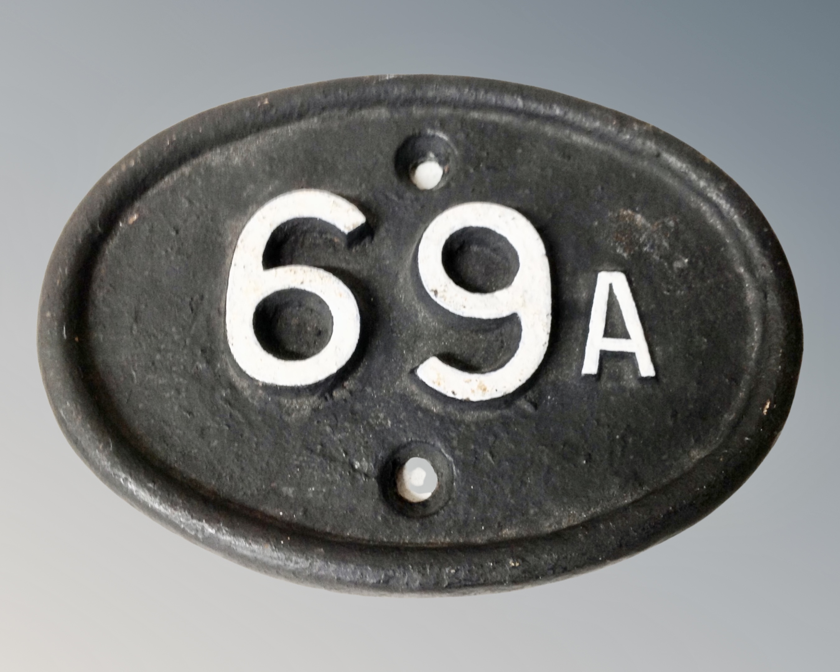 A cast iron British Railway shed marker from Finsbury Park in London, '69a'.