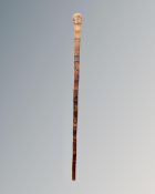 A vintage Oriental carved bamboo walking stick depicting geishas.
