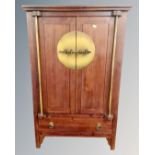 A Chinese style double door cabinet fitted with drawer beneath,
