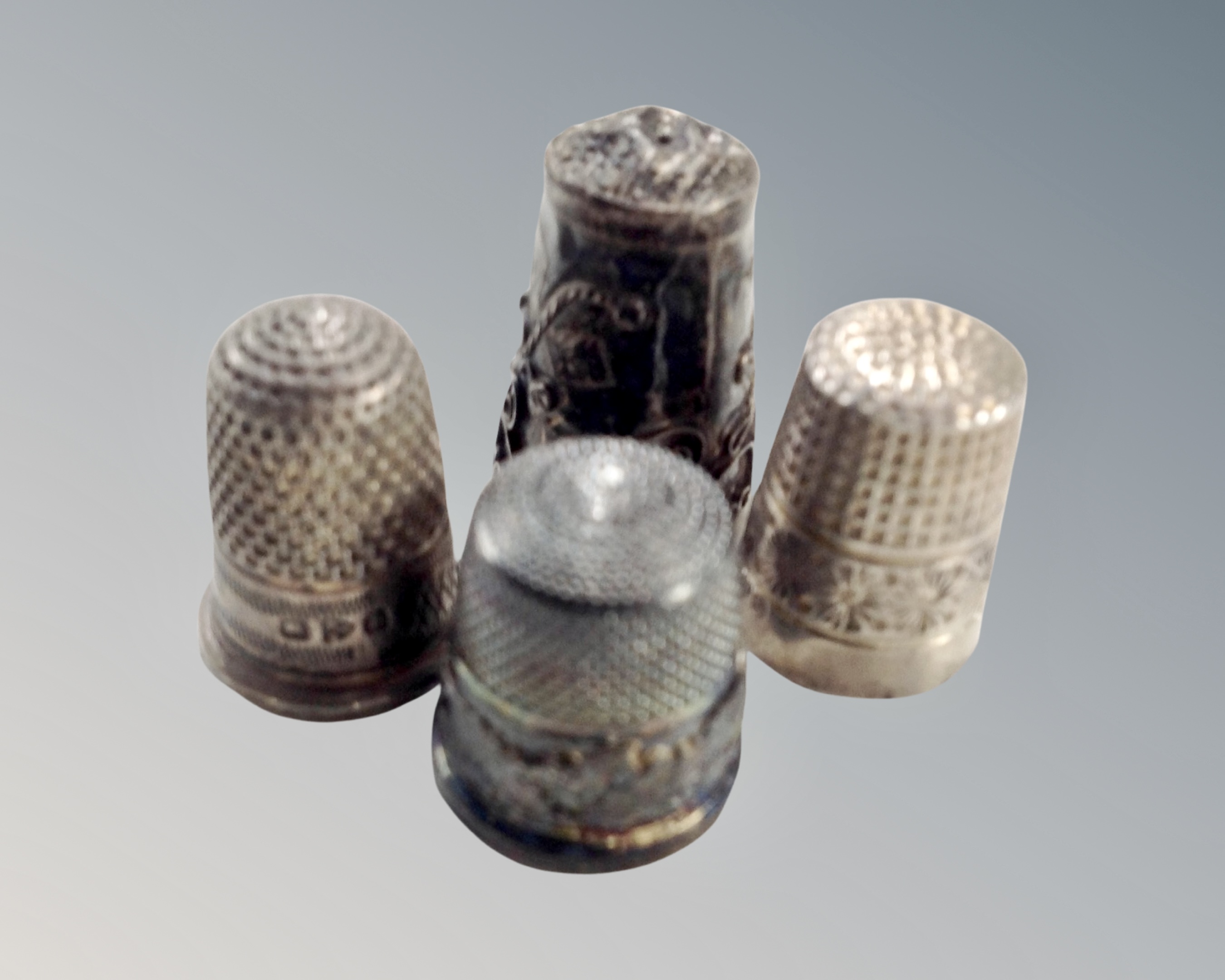 Four hallmarked silver thimbles.