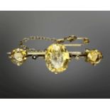 A Victorian yellow metal citrine and seed pearl bar brooch with safety chain, width 37mm.