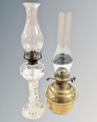 A duplex brass oil lamp with chimney together with a further clear glass oil lamp with chimney.