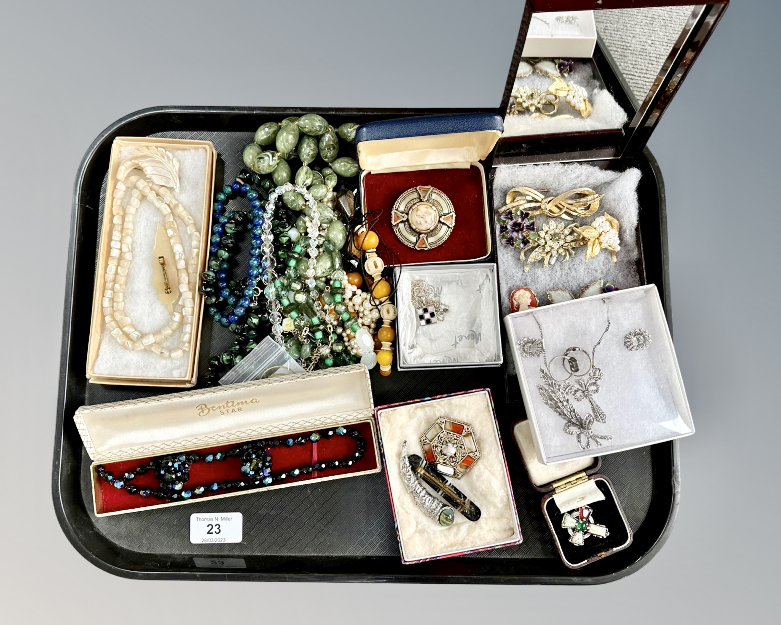 A tray of mixed costume jewellery including Scottish hard stone brooches, bead necklaces,