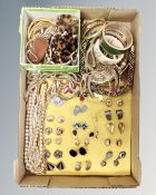 A tray containing a quantity of gold-finished costume jewellery, bangles,