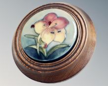 A Moorcroft circular plaque mounted in a wooden frame.