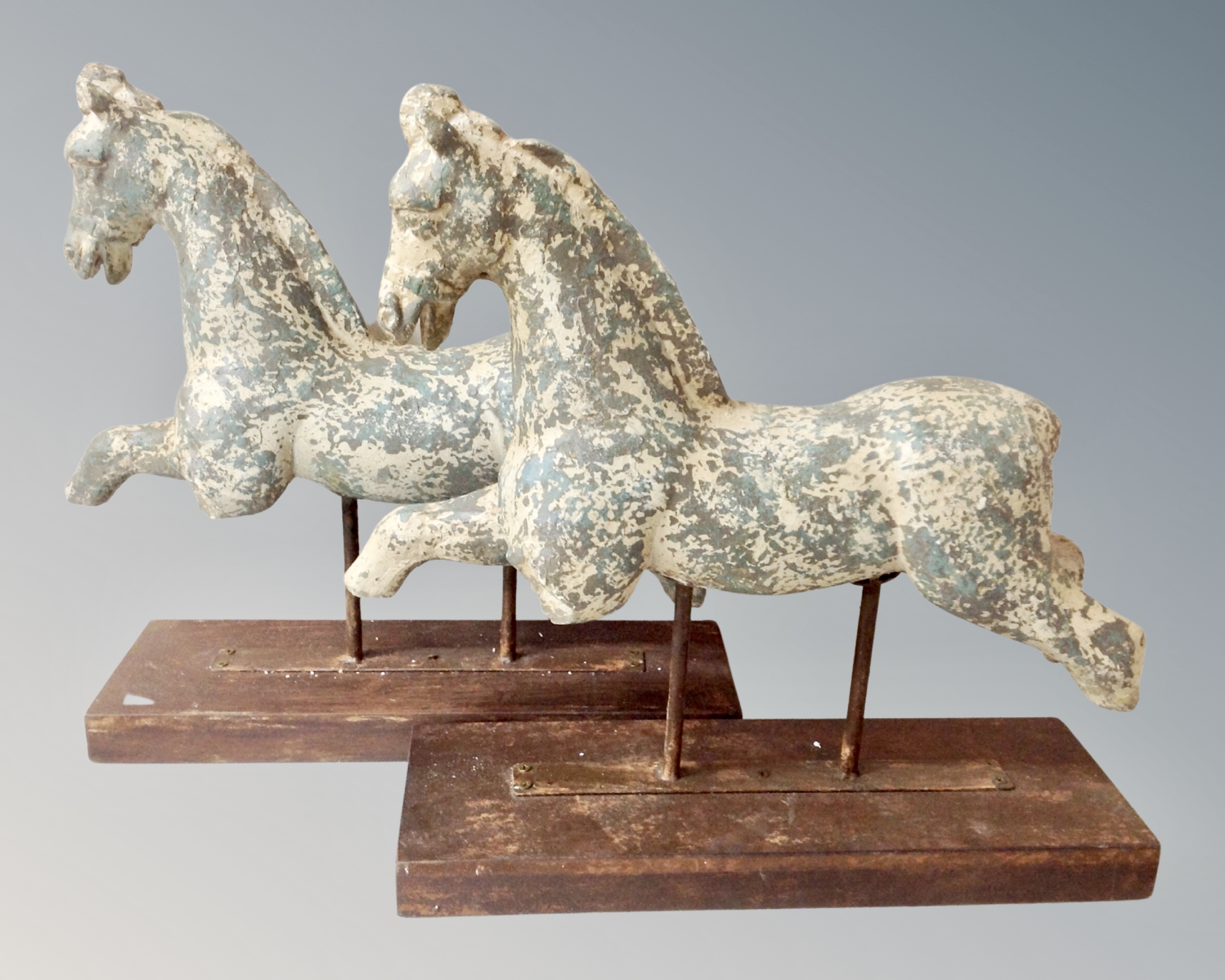 A pair of contemporary horse sculptures on stands, height 51 cm.