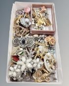 A small white tray of costume jewellery including stickpins, lapel pins, brooches etc.
