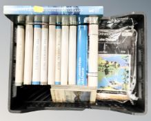 A basket containing a full set of seven Wainwright pictorial books of the Lake District including a