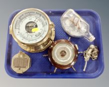 A tray containing nautical themed items including a Schatz brass cased ship's clock,