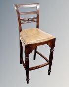 A reproduction ladderback bar chair with tan leather seat.