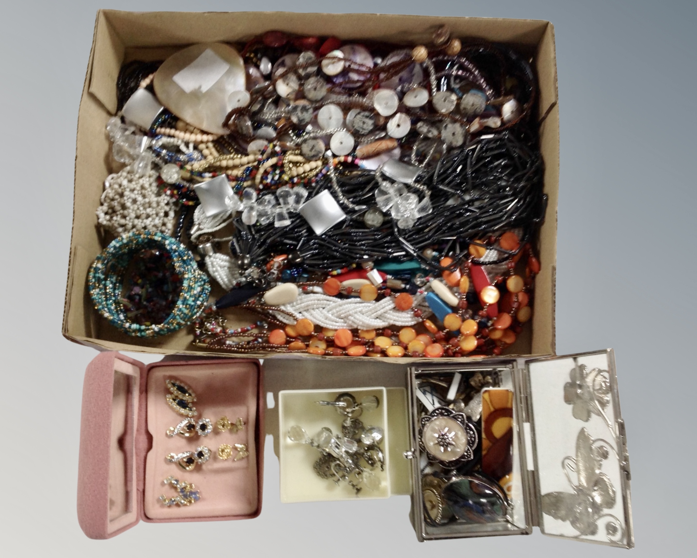 A tray containing a quantity of assorted costume jewellery including dress earrings, necklaces,