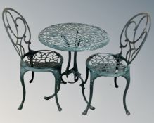 A wrought metal circular garden table and two chairs