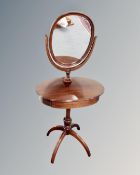 An oval mirrored dressing table fitted with a drawer.