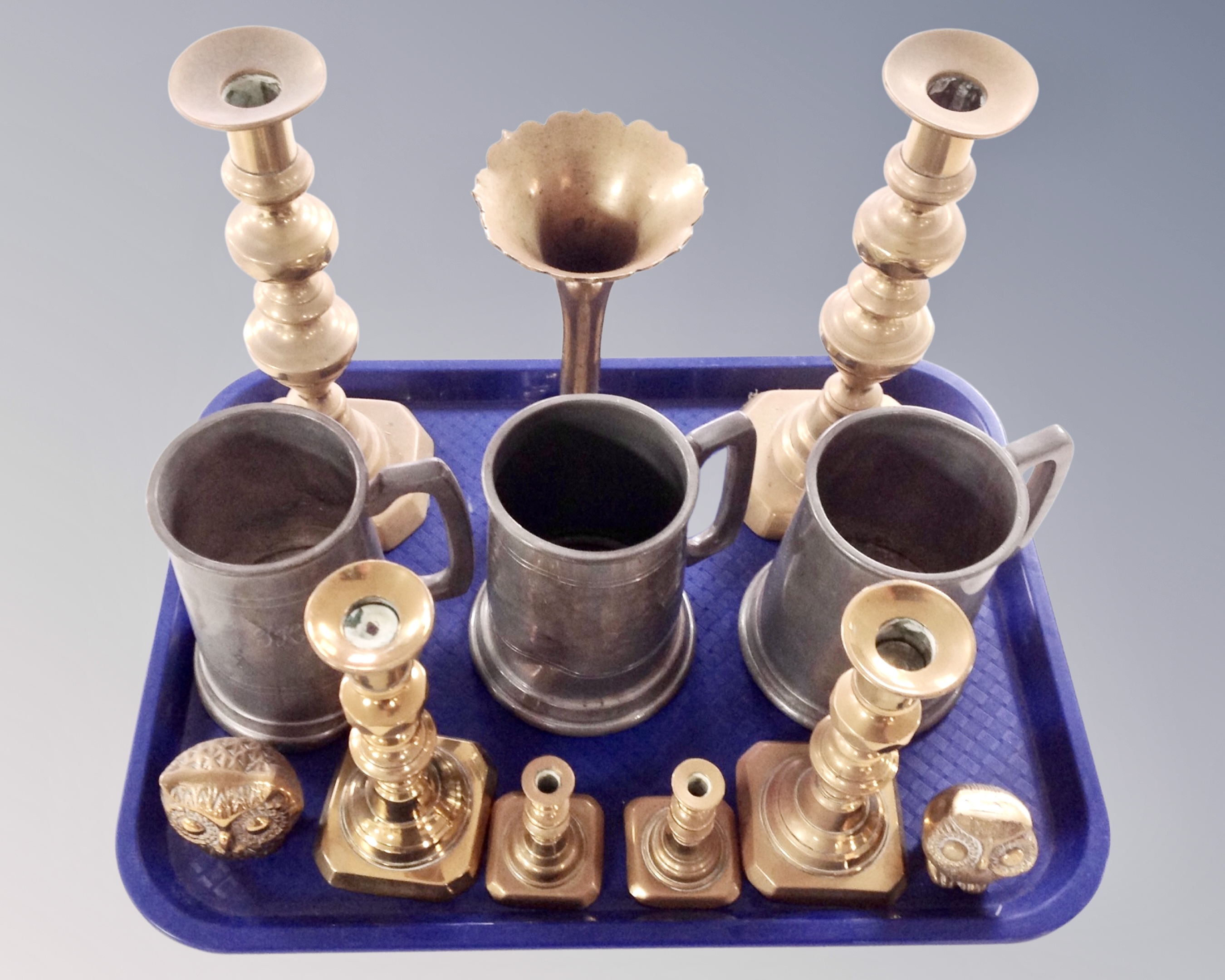 A tray containing antique metal wares including candlesticks, a pair of owl ornaments, fluted vase,