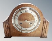 A 1930s oak cased eight-day mantel clock.