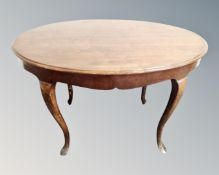 An oval beech low table on cabriole legs.