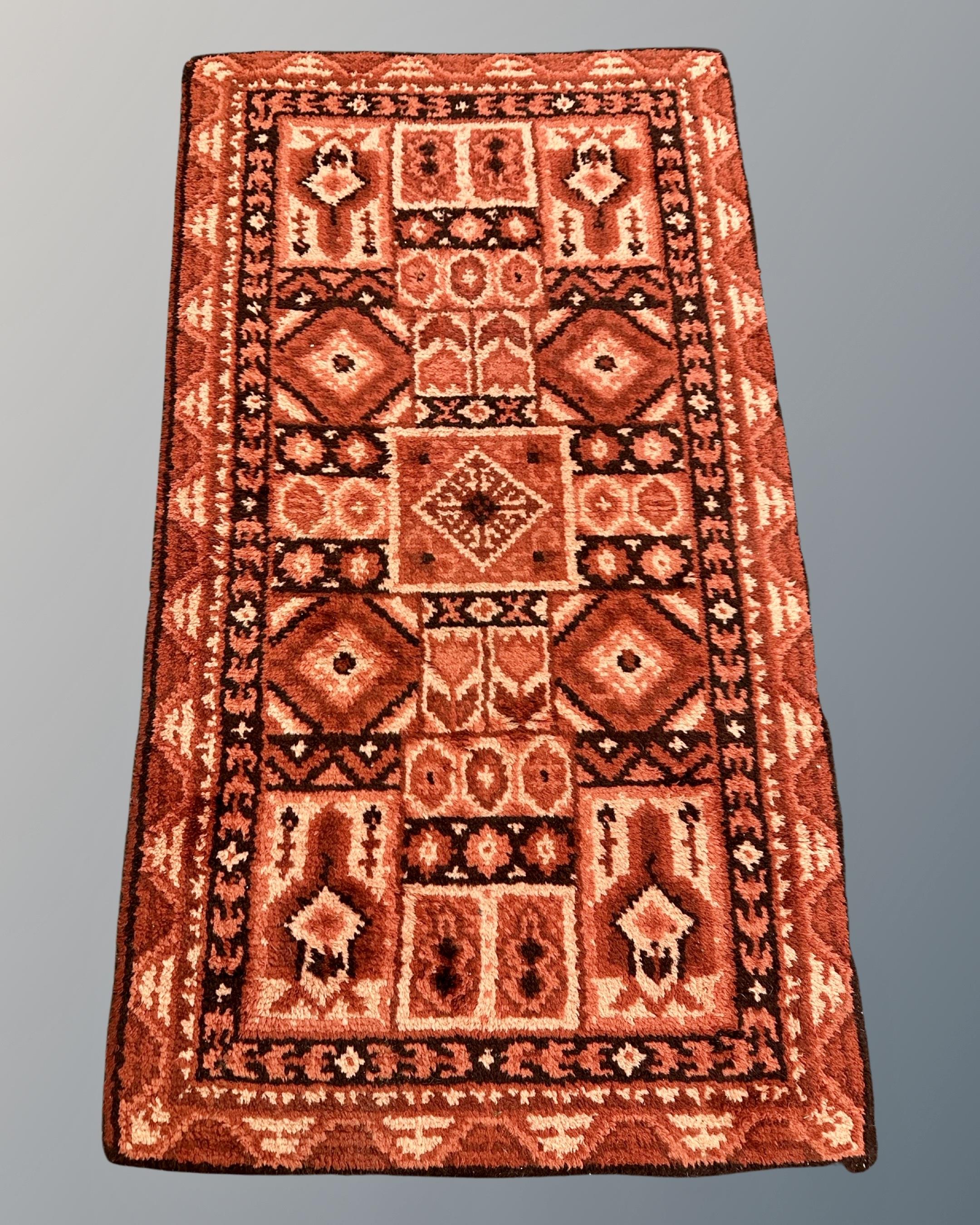 An Afghan design rug, 98cm by 170cm.