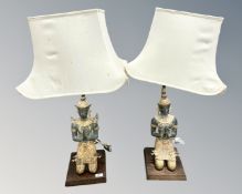 A pair of patinated metal figural table lamps depicting Taiwanese figures praying, with shades.