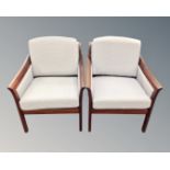 A pair of teak framed Scandinavian armchairs.