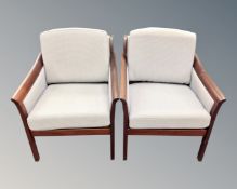 A pair of teak framed Scandinavian armchairs.