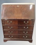 A reproduction inlaid mahogany bureau fitted four drawers
