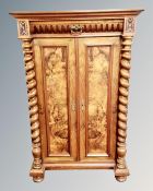 A 19th century continental burr walnut and beech double door cabinet with barley twist supports.