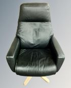 A Soderbergs of Sweden black leather swivel armchair on four way support.