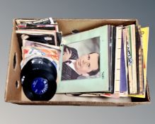 A box containing vinyl records and 7" singles including Western compilations, Iron Maiden,