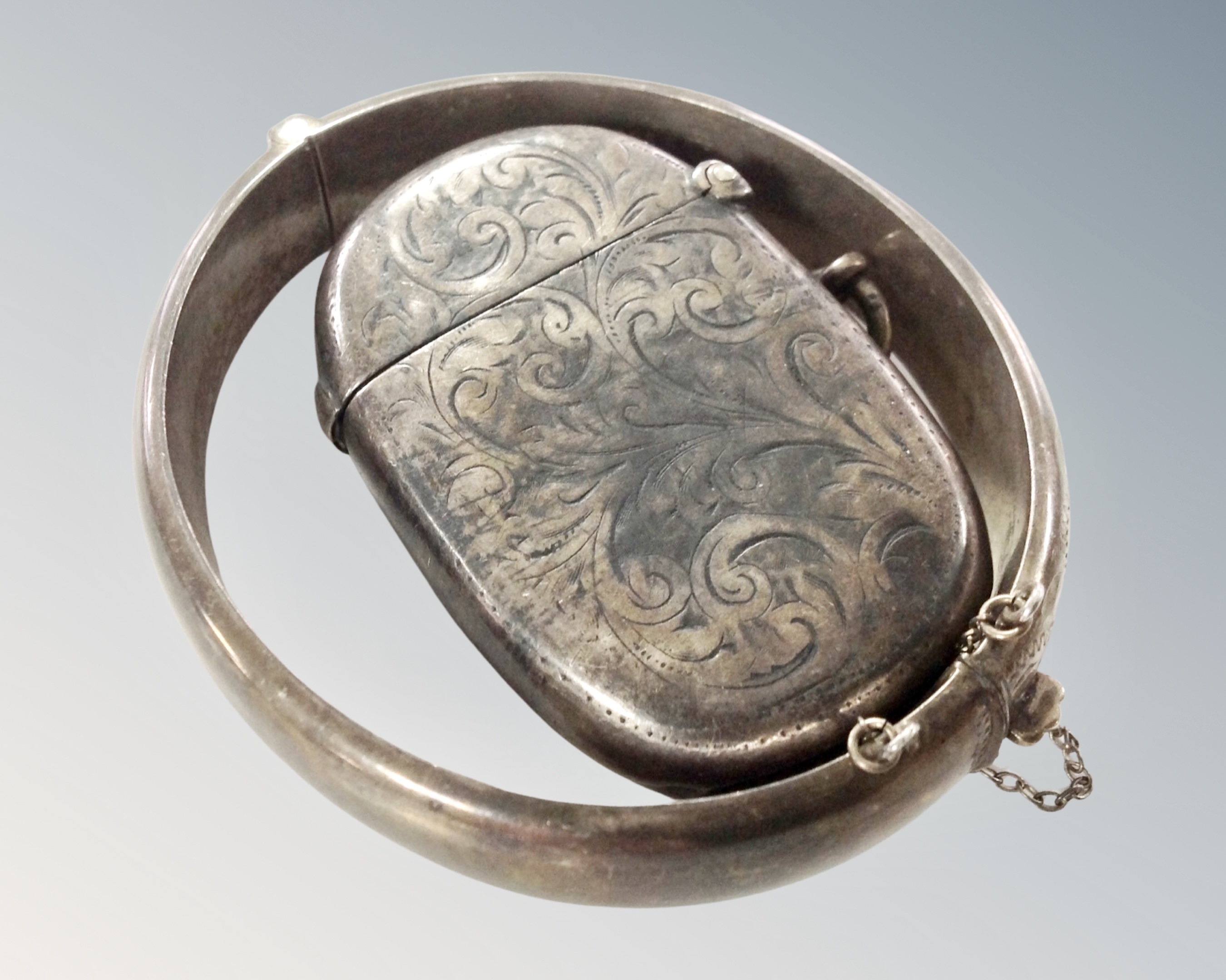 An engraved silver bangle together with a silver vesta case.