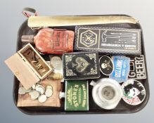 A tray containing English crowns, Mexican coins, hip flask, metal belt buckles, miniature tool sets.