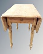 An early 20th century pine drop leaf kitchen table.