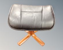 A contemporary black leather footstool on four way teak support.