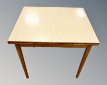 A pine effect mid-20th century extending dining table.