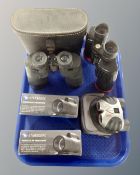 A tray containing three pairs of field glass including Tasco, Minolta and Praktica, two cased,