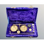 A set of brass portable balance scales in fitted case, with weights and tweezers.