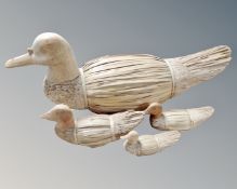 Four graduated wood and wicker duck ornaments.