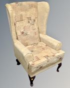 A wingback armchair in golden fabric