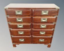 A campaign style ten drawer chest with brass drop handles.