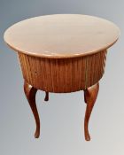A mahogany circular storage occasional table on cabriole legs.