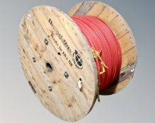 A large wooden spool of fibre optic cable