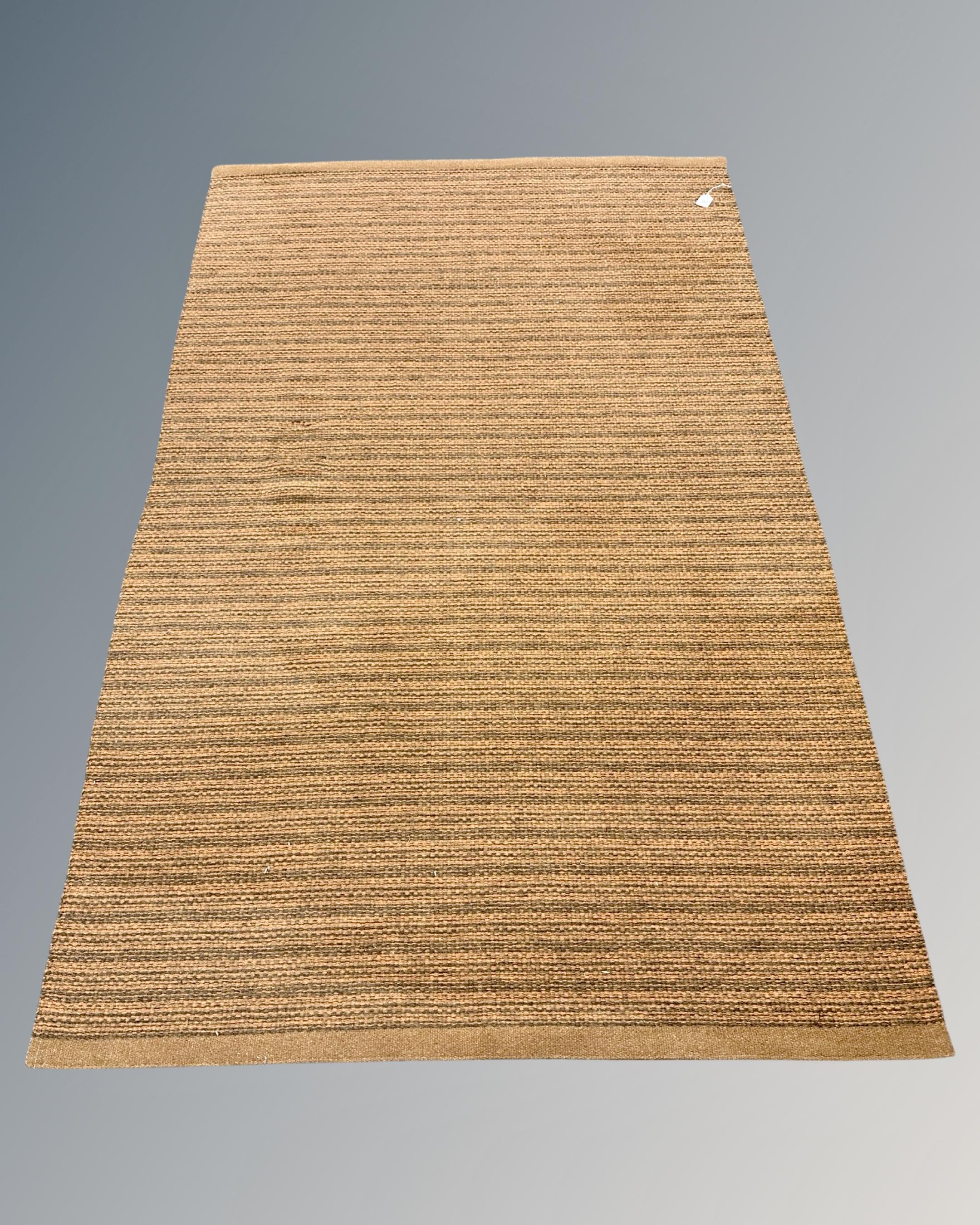 A contemporary rug on brown ground, 129cm by 202cm.