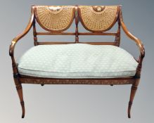 A Victorian style painted bergere backed two seater open settee