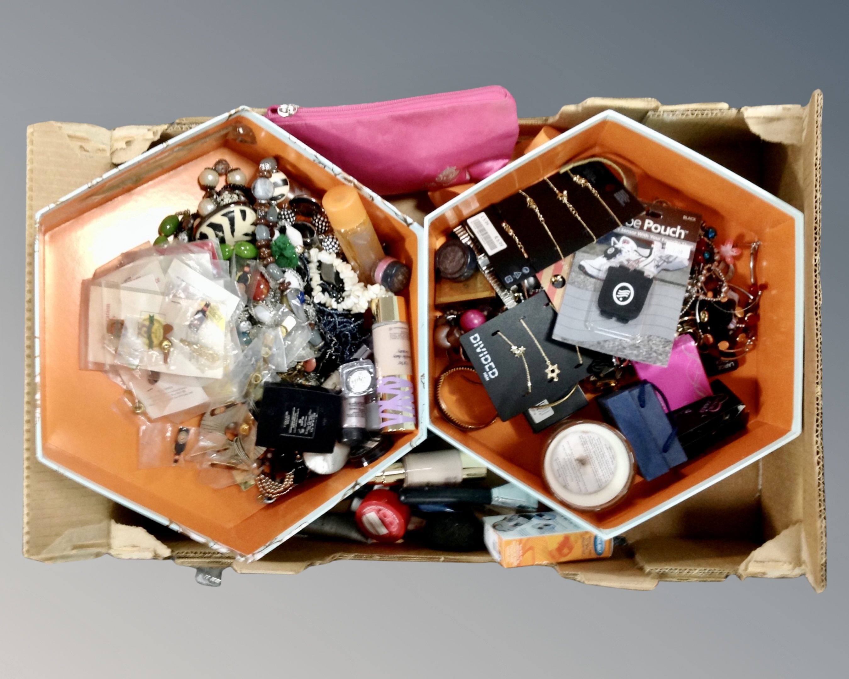 A box containing a quantity of assorted costume jewellery and beauty products.