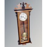 A Continental walnut and ebonized Vienna style eight-day wall clock with white enamelled dial.
