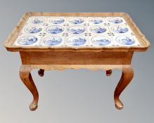 A Dutch oak coffee table with Delft tile inset top.
