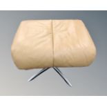 A tan leather footstool on four way chrome pedestal.