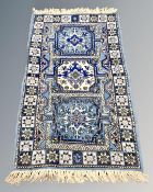 A Caucasian design rug on blue ground, 152cm by 82cm.